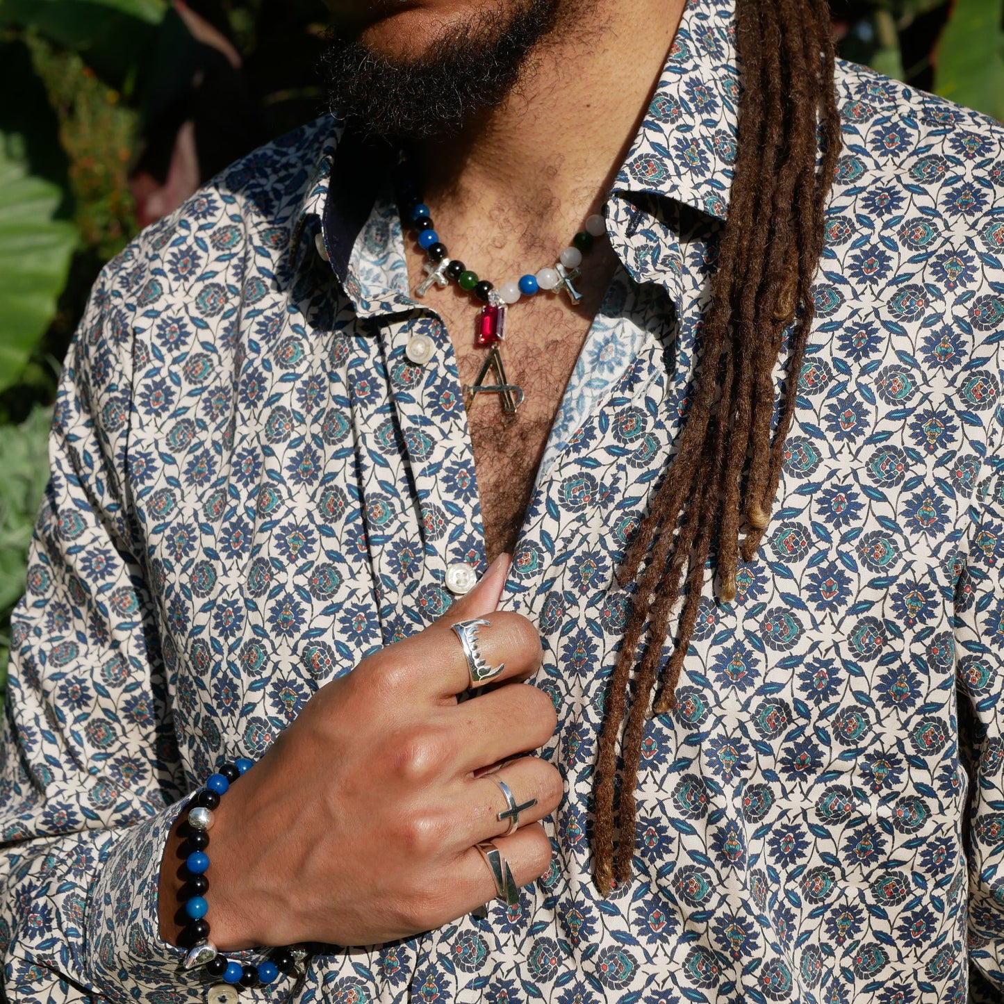 A black man wearing a Big fang ring and 2 other rings with his and on his chest