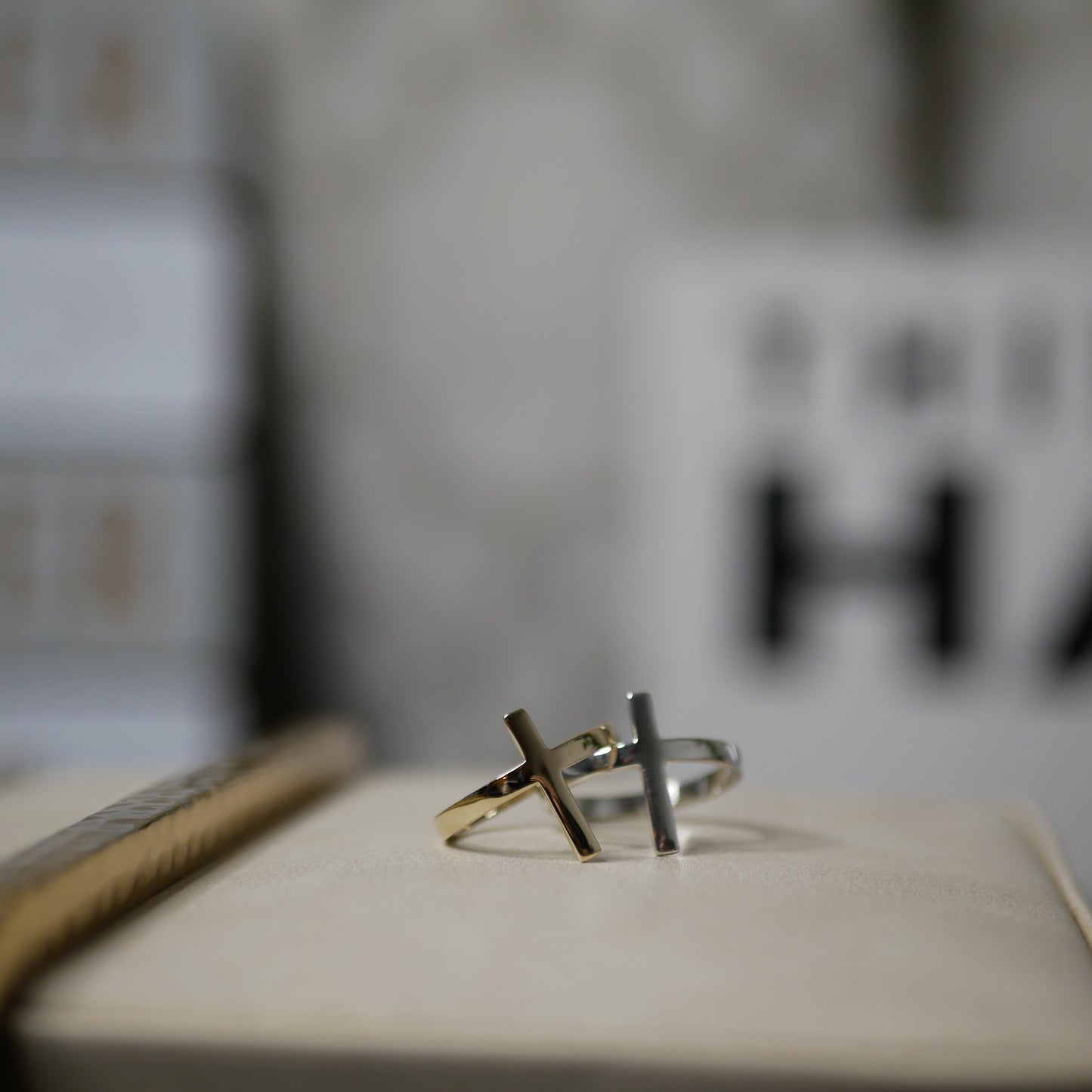 One gold ring and one silver ring shaoed like a cross sitting together